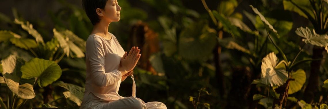 Serene scene of a woman meditating in a lush garden setting at daylight.