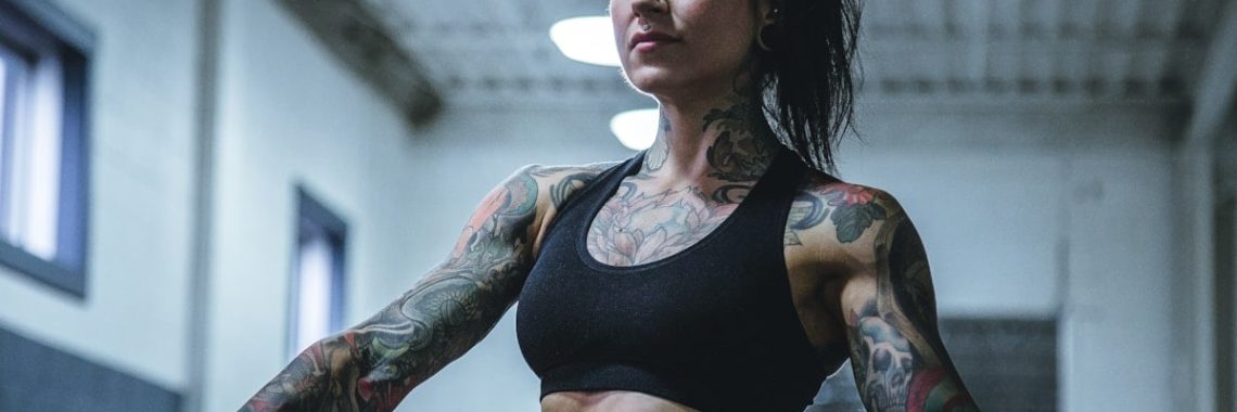 woman wearing black sports bra with tattoos